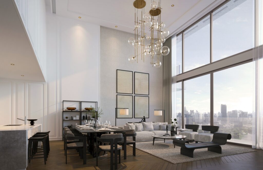 A double-height living and dining room at Dusit Residences, with a sculptural chandelier