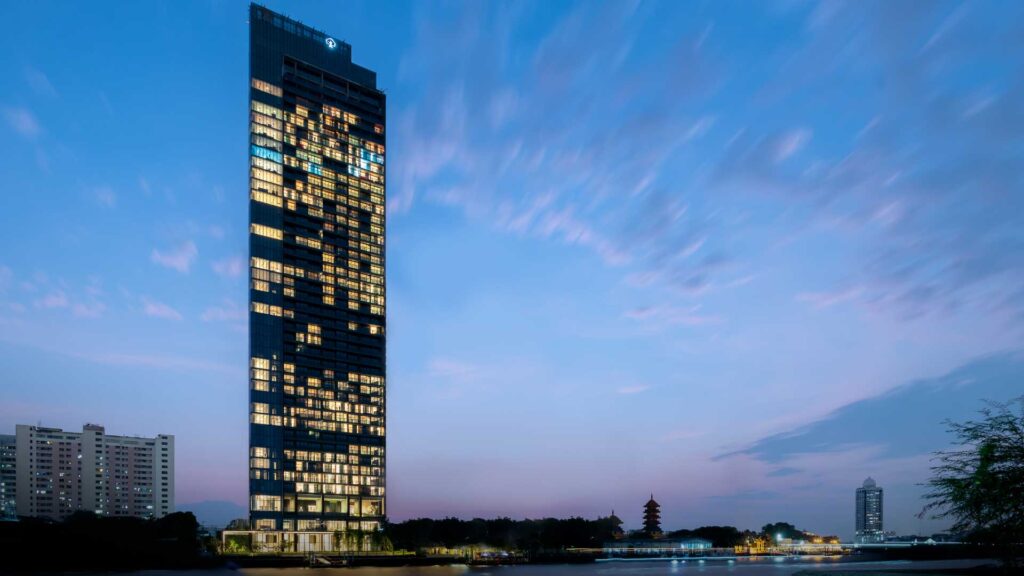 The Banyan Tree Residences Riverside tower lit at dusk on the Chao Phraya