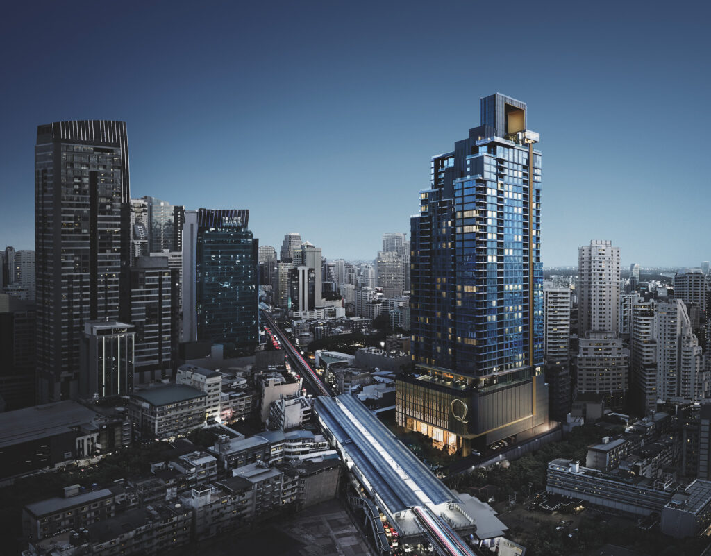 The Q1 Sukhumvit tower at dusk above Nana, with the BTS line running below
