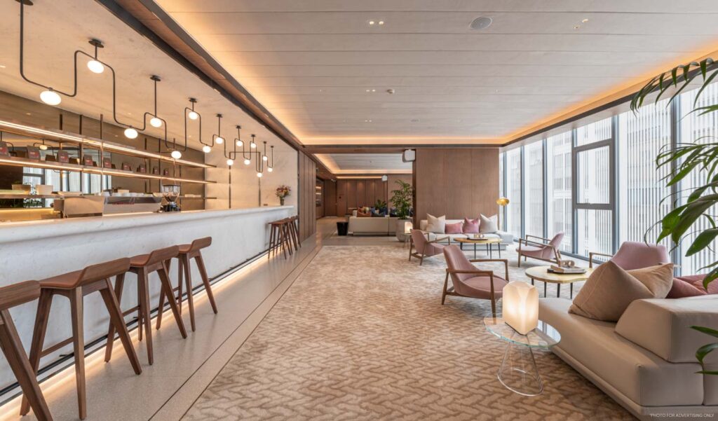 A residents' lounge and bar counter at SCOPE Langsuan, lined in pale timber