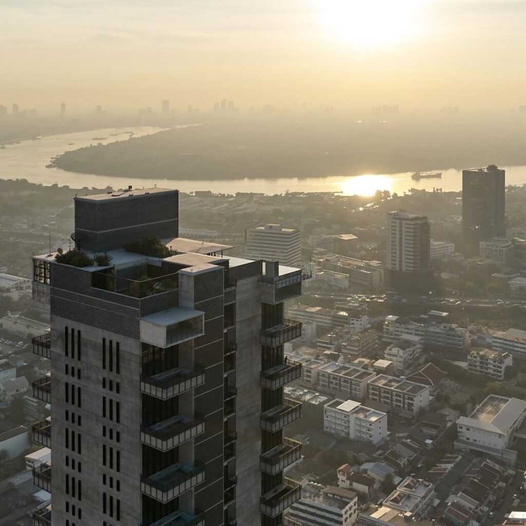 The rooftop of the Windshell Naradhiwas residence at sunrise, with the Chao Phraya beyond