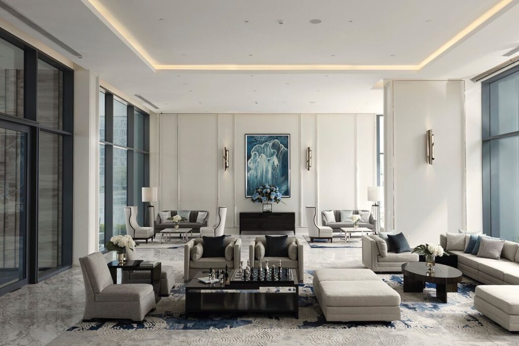 A formal white living room at Q1 Sukhumvit with grey sofas and framed artwork
