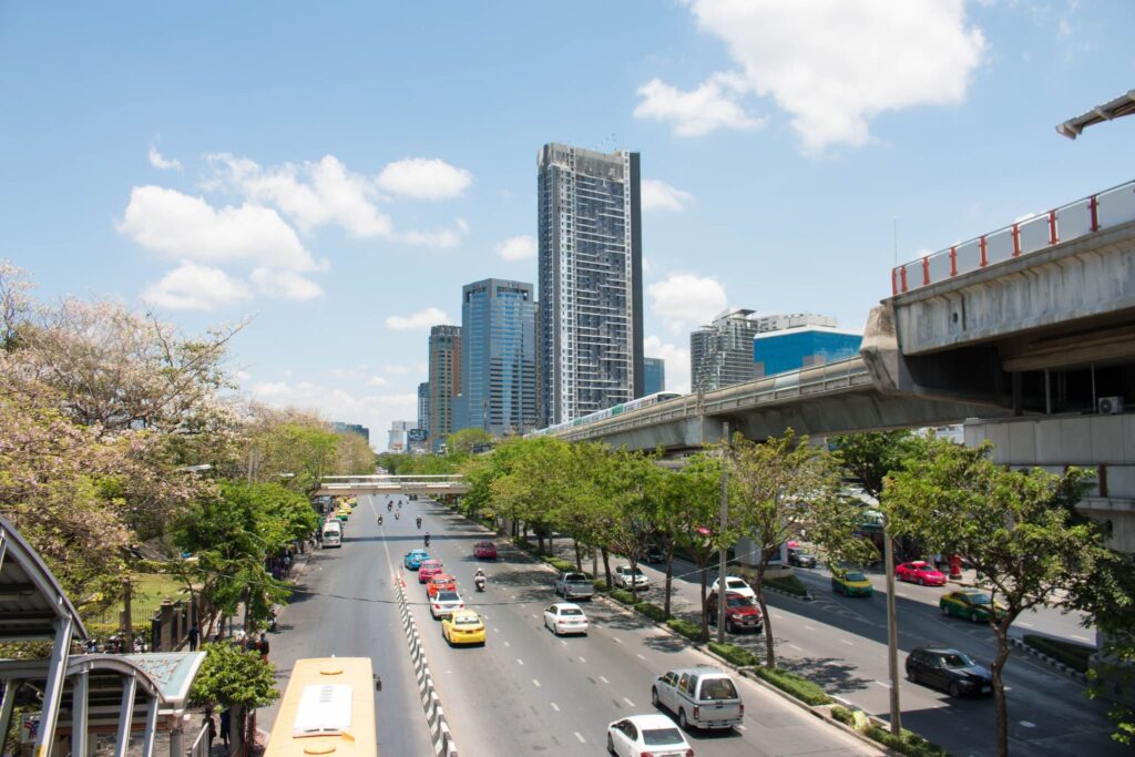 A main road through the Ladprao and Chatuchak district, lined with trees, towers and the elevated rail