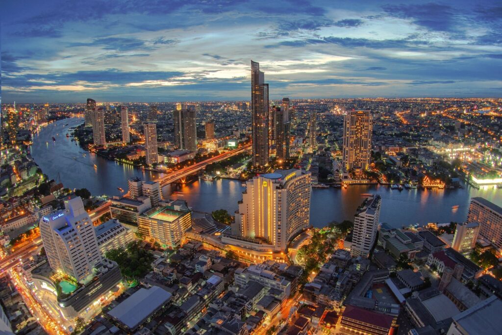 The Thonburi riverside at dusk, looking along the Chao Phraya toward the city