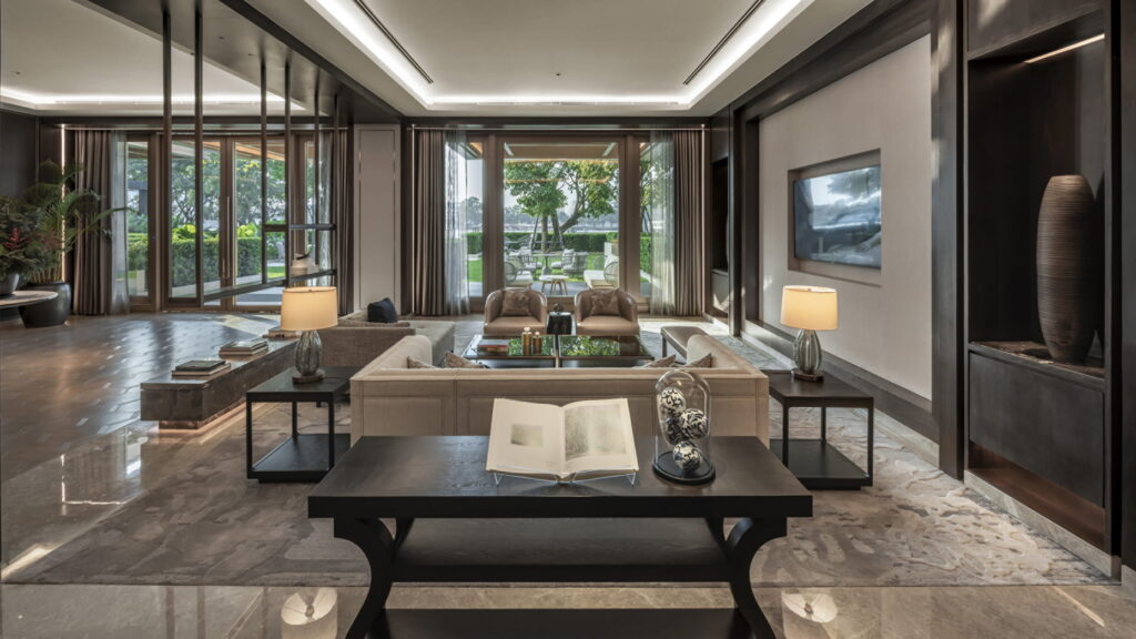 A dark-toned residents' lounge at Four Seasons Private Residences, opening to a garden view