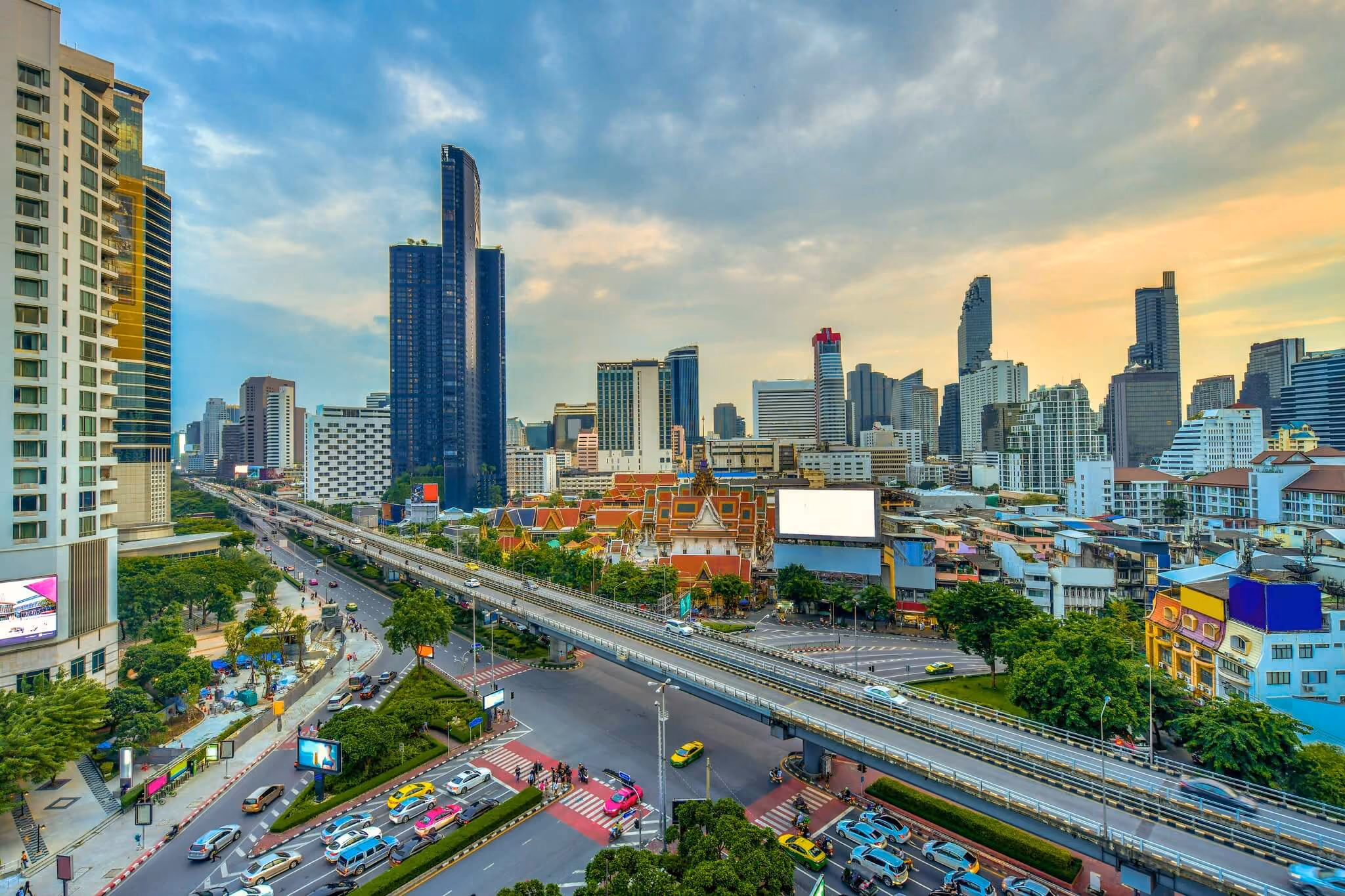 Traffic along Rama IV Road, with the elevated expressway and the Bangkok skyline beyond