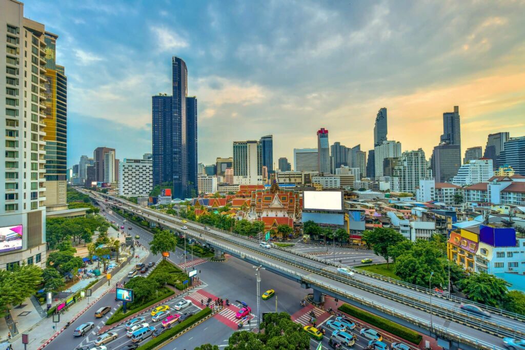 Traffic along Rama IV Road, with the elevated expressway and the Bangkok skyline beyond