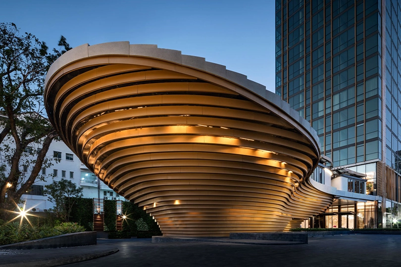 The curved gold pavilion at the base of The Monument Thonglor