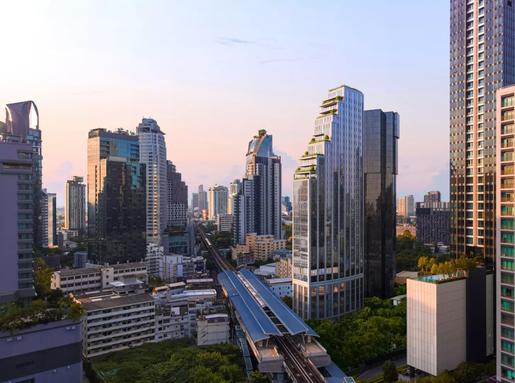 Daytime skyline with BTS skytrain track curving past condominium towers and green trees