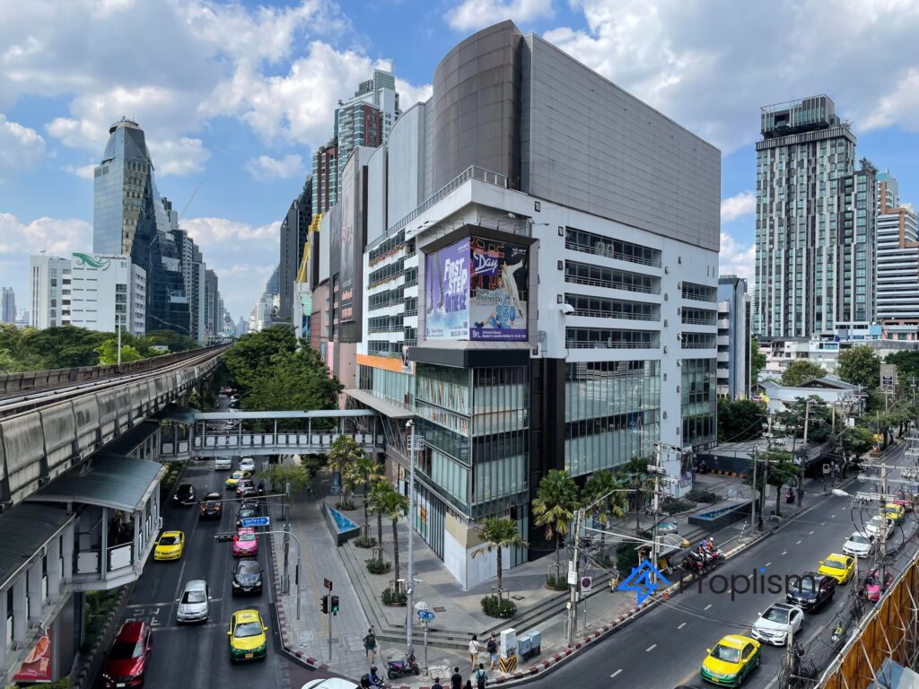 Wide street view of the Ekkamai mall, skytrain track, taxis and pedestrian bridge