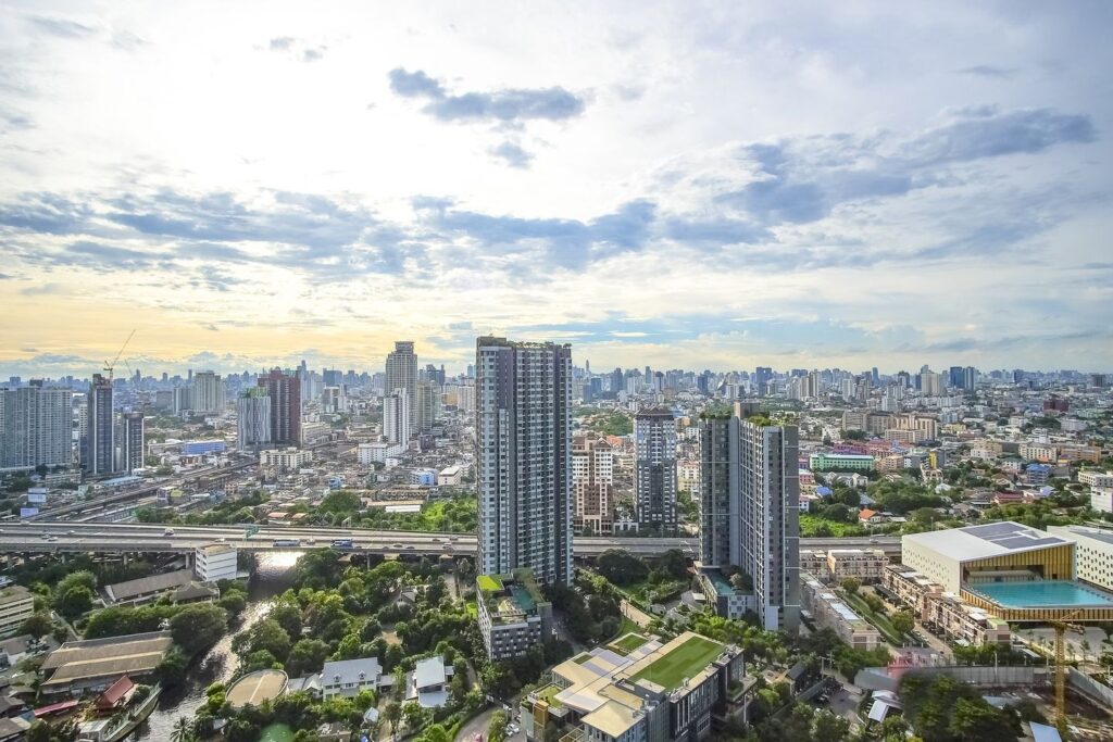 Larger daytime crop of On Nut skyline, pool deck, green rooftops and distant towers