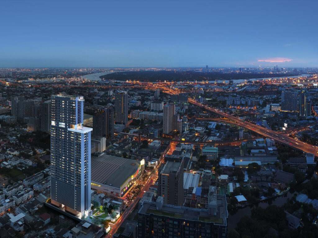 Dusk aerial over dense On Nut rooftops with a pale high-rise tower and orange street lights