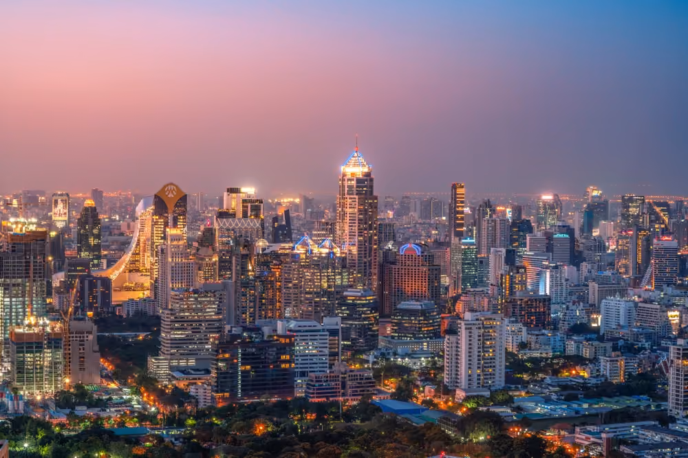 Pink dusk panorama of lit central Bangkok high-rises stretching to the horizon
