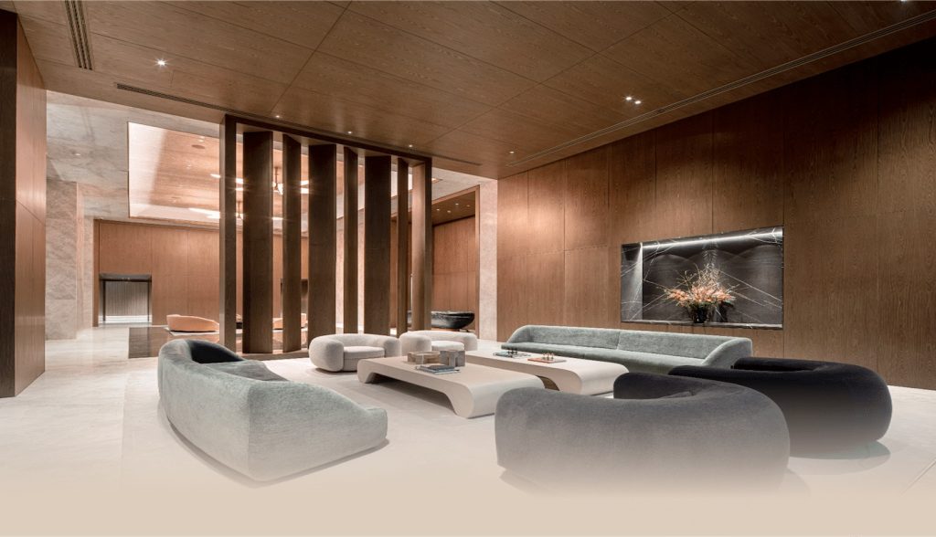 Warm timber-lined lobby with sculptural pale sofas, stone floor and fireplace