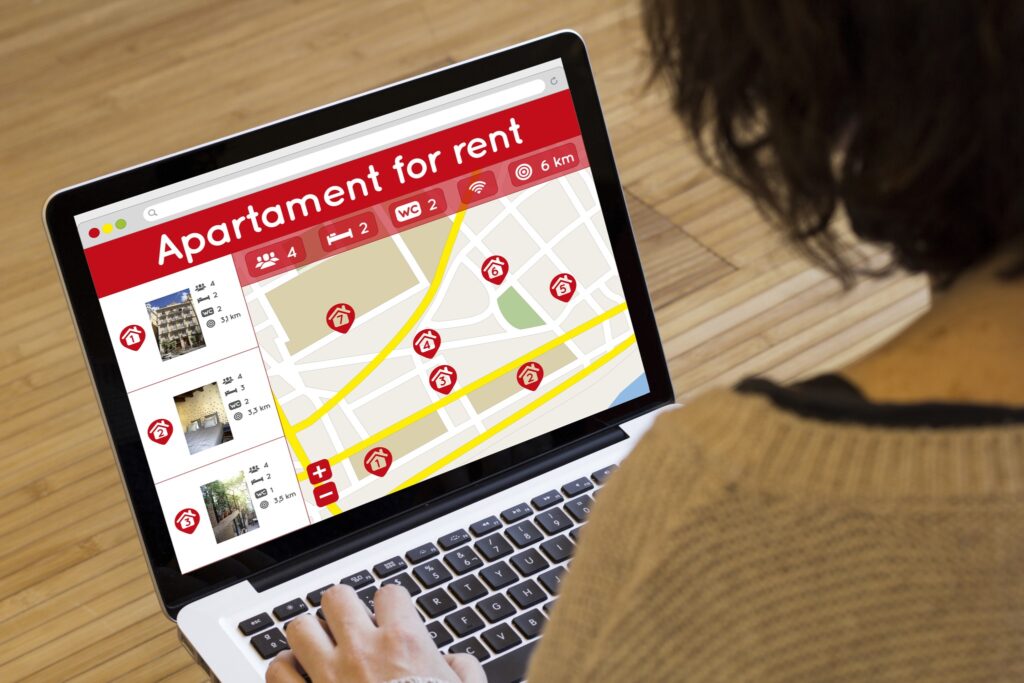 Person browsing an apartment for rent listing and map on a laptop screen
