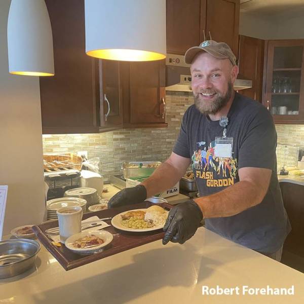 Caregiver Robert in the kitchen presenting a home cooked meal
