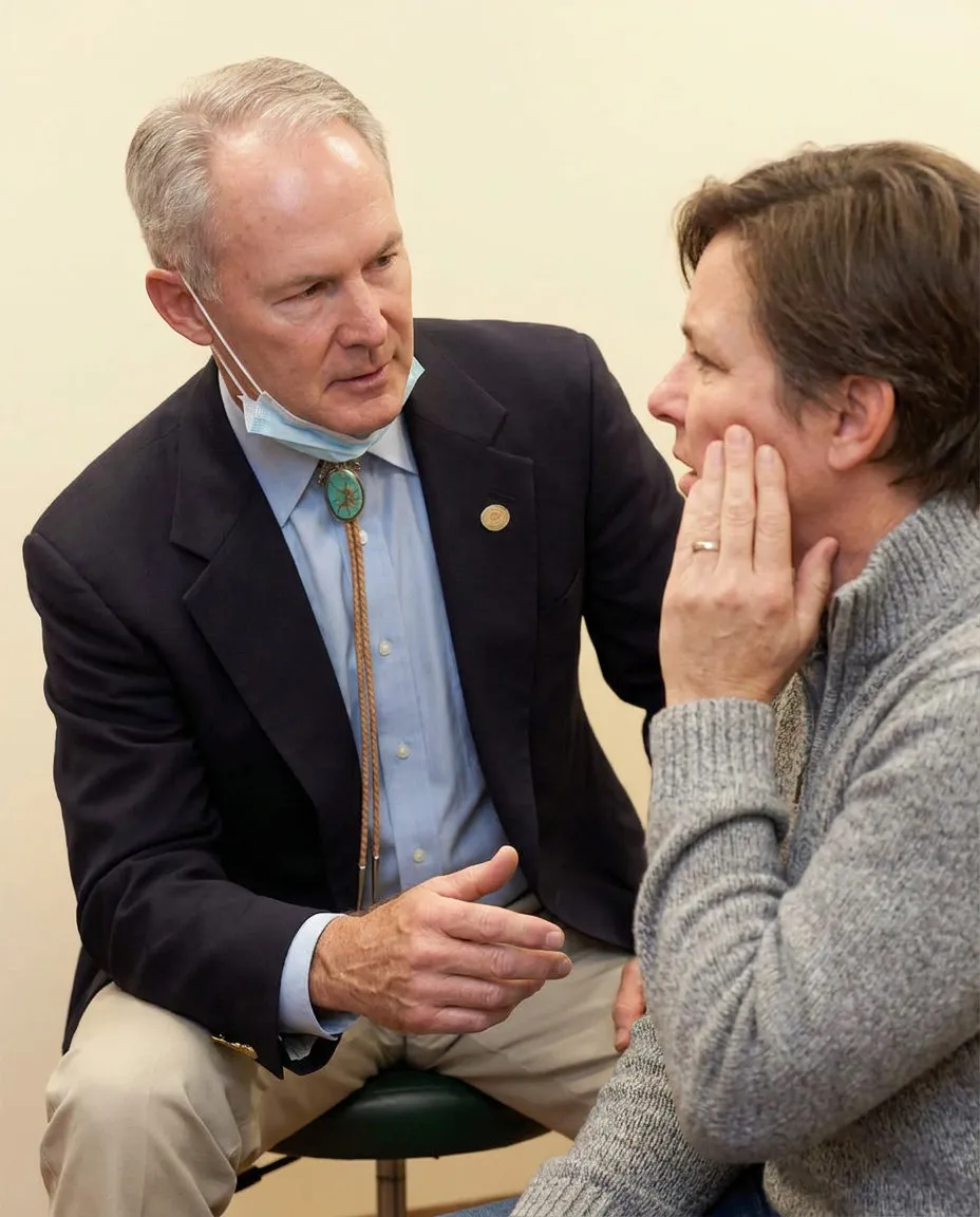 Dr. Steven T. Cutbirth listens to an emergency patient in Waco, TX while they describe symptoms and hold their cheek.