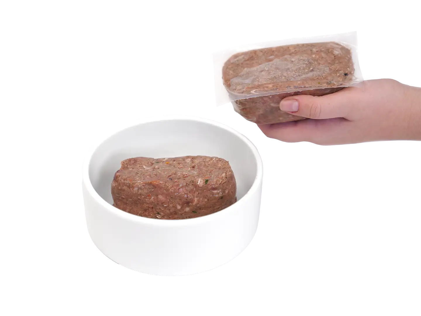 Leading Raw dog food patty served in a white bowl, beside a hand holding a sealed frozen portion.