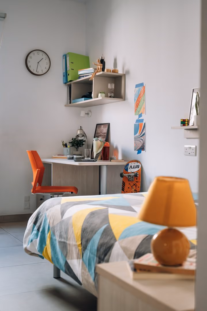 A Campus Hub bedroom with a patterned bedspread and study desk