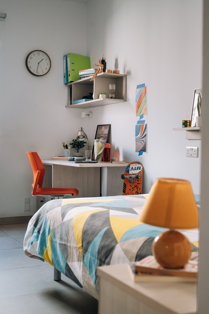 A Campus Hub bedroom with a patterned bedspread and study desk