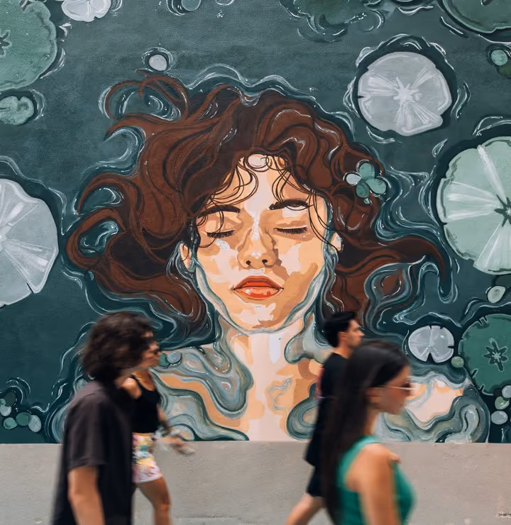Students walking past a painted mural in the piazza