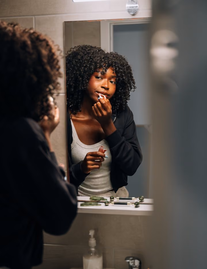 A student getting ready at the bathroom mirror