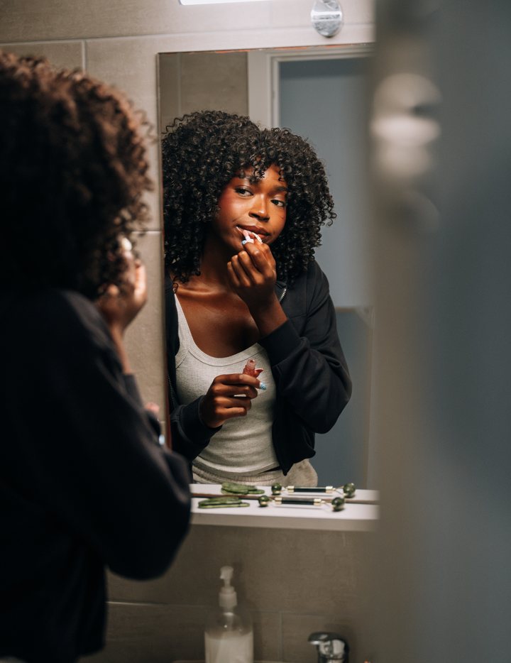 A student getting ready at the bathroom mirror