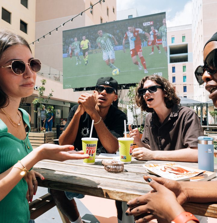 Students watching football together on an outdoor screen