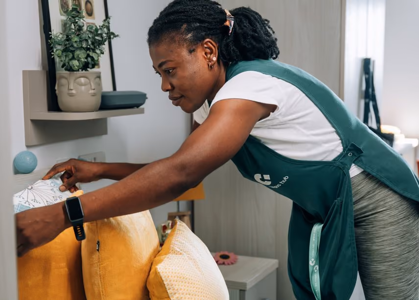 A member of the housekeeping team making up a room