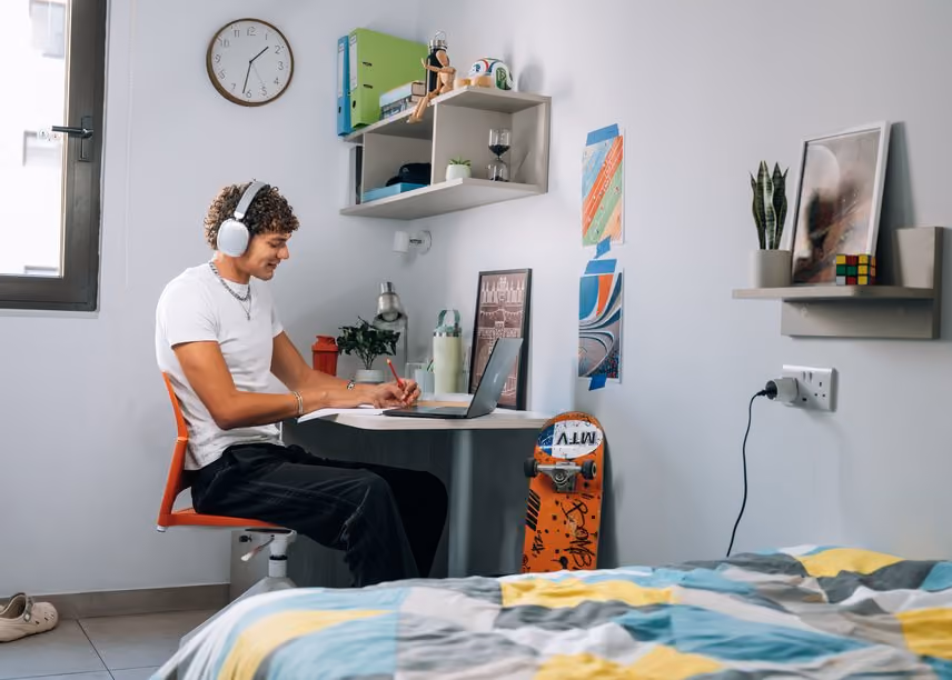 A student working at the desk in their room