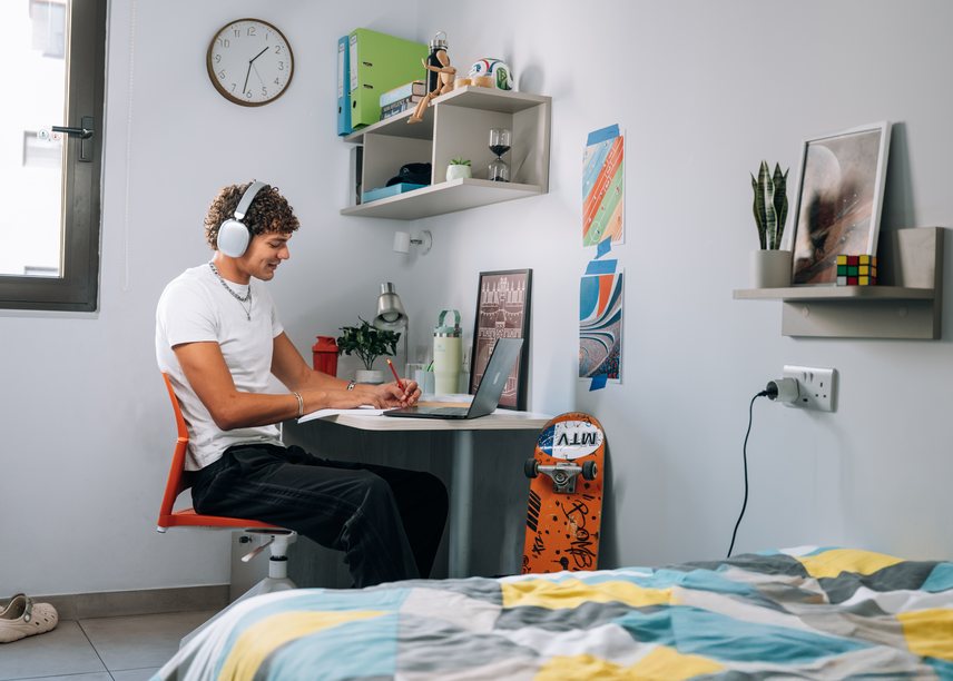 A student working at the desk in their room