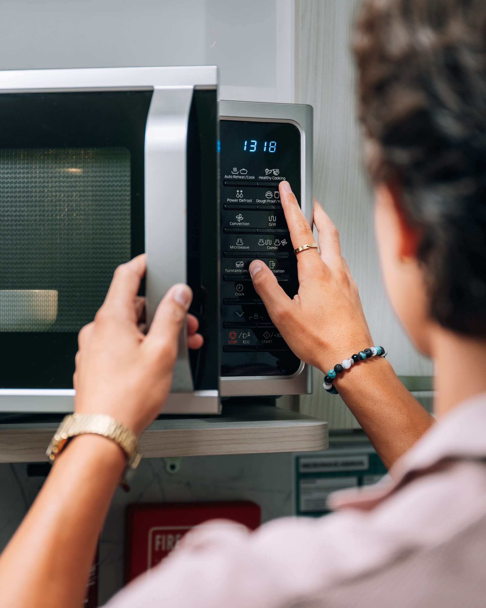 Close-up of a student setting the microwave in a Solo room's in-room kitchen
