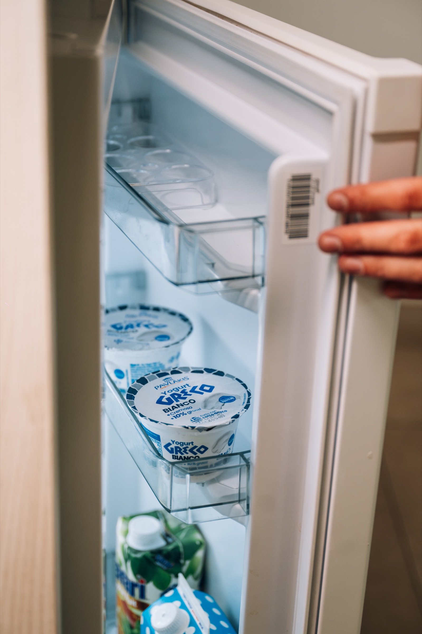 Open under-counter fridge in a Solo room, stocked with yoghurt and milk