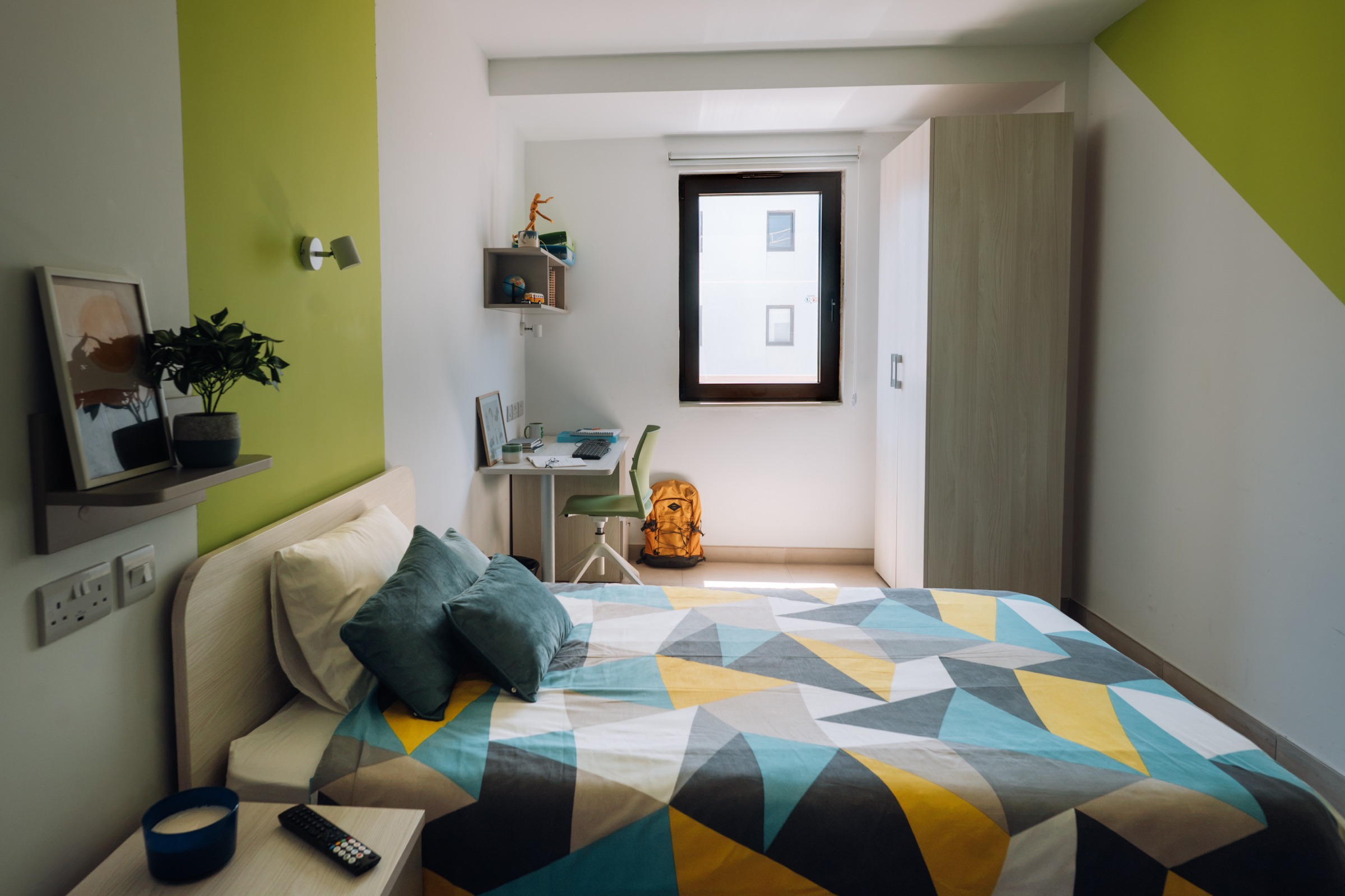 Solo room with a double bed, a desk under the window and a full-height wardrobe