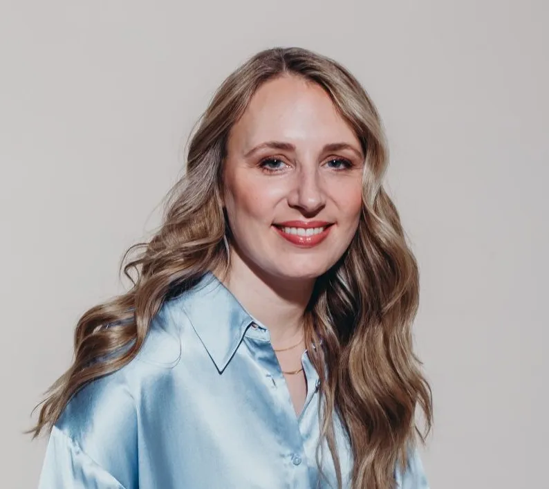 Porträt von Melanie Bosse, lächelnd in hellblauer Bluse