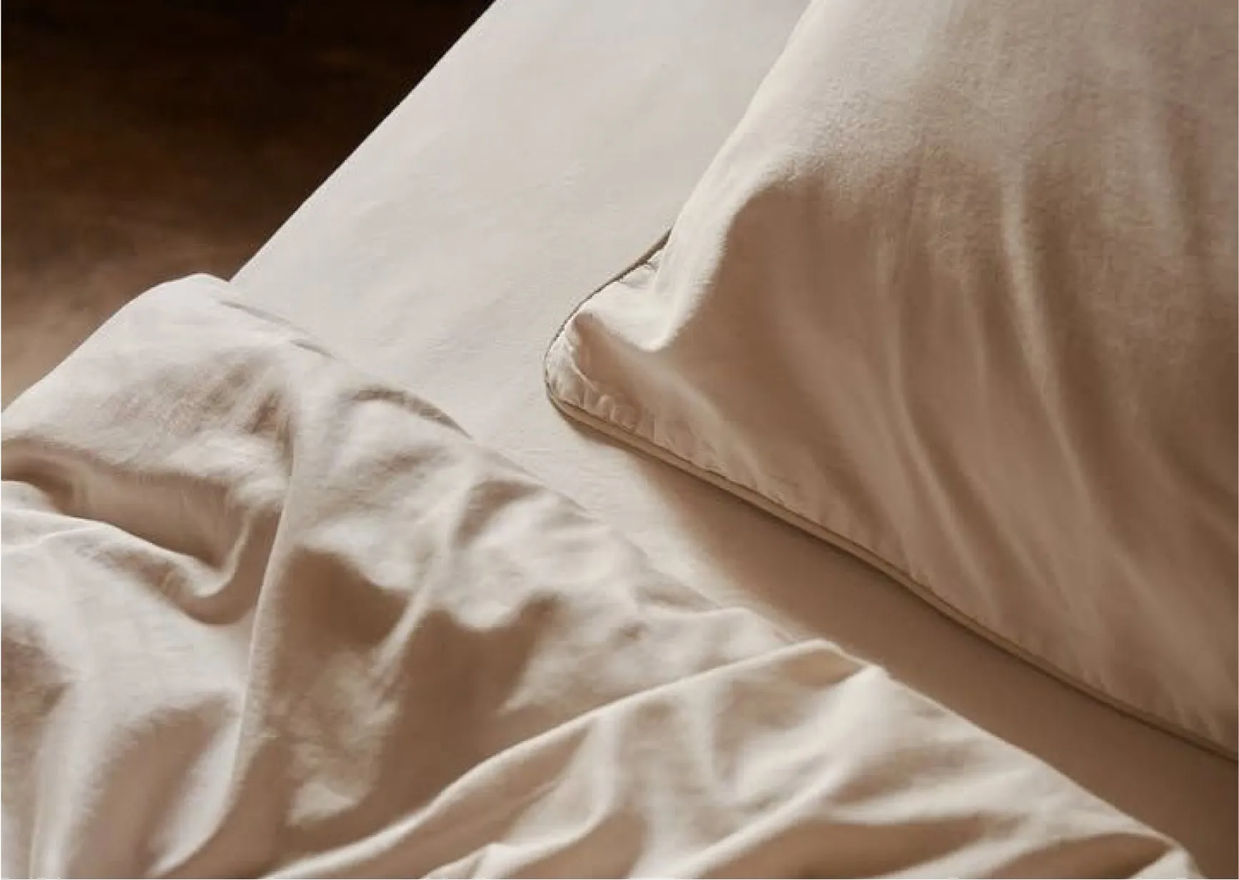 Minimalist bedroom with white bedding representing healthy sleep, recovery and restorative rest.