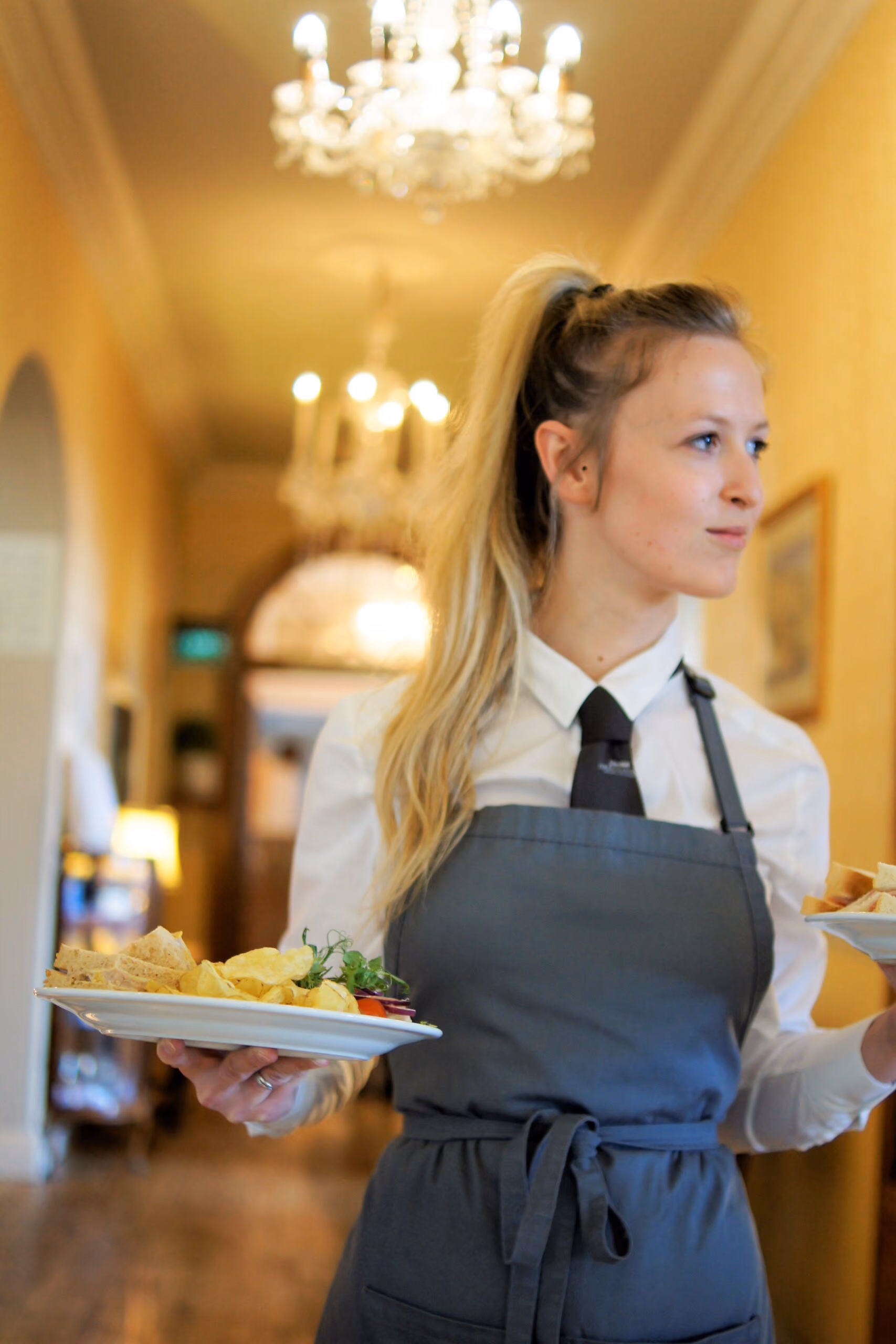 Waitress carrying plates through The Bulkeley Hotel