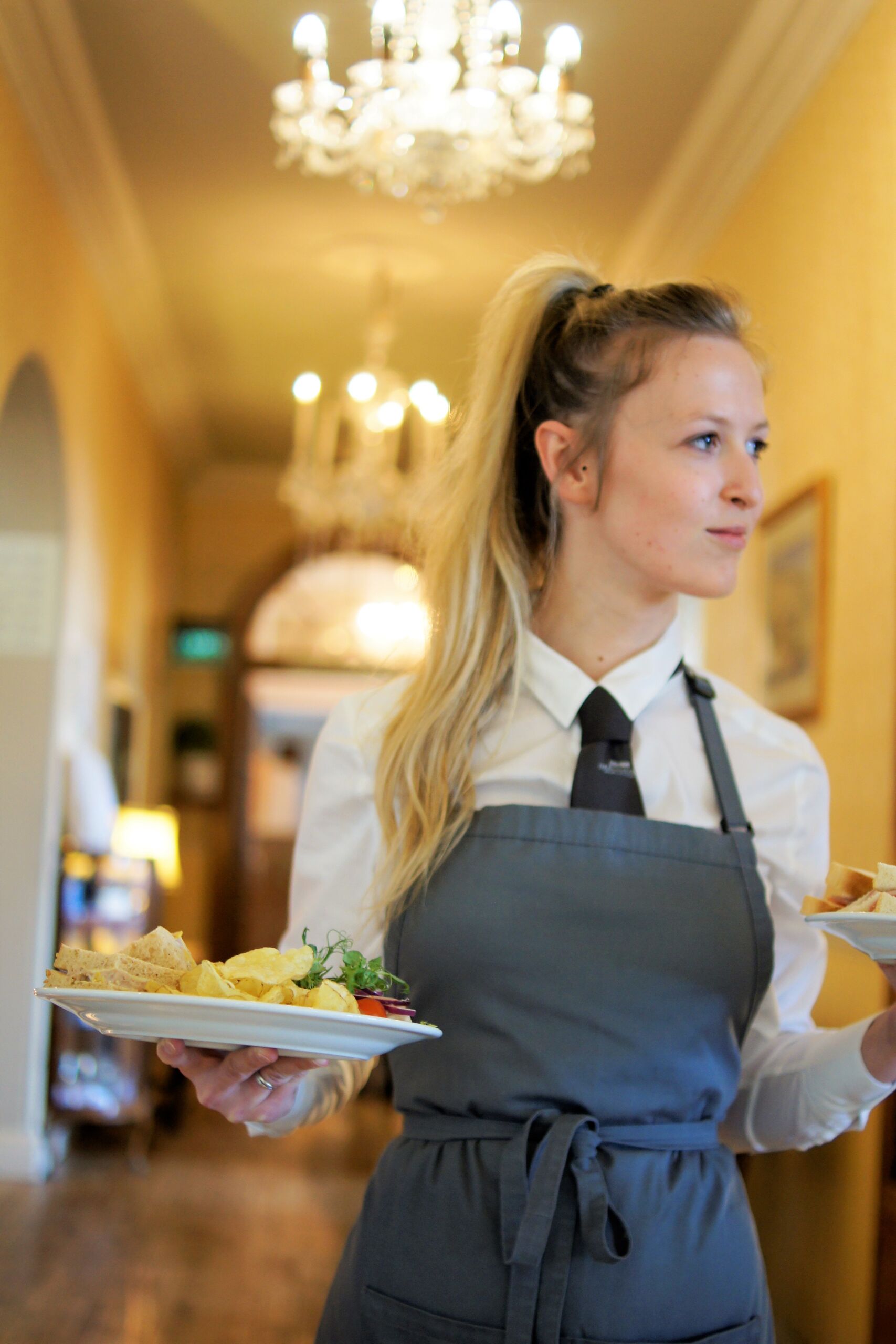 Waitress carrying plates through The Bulkeley Hotel