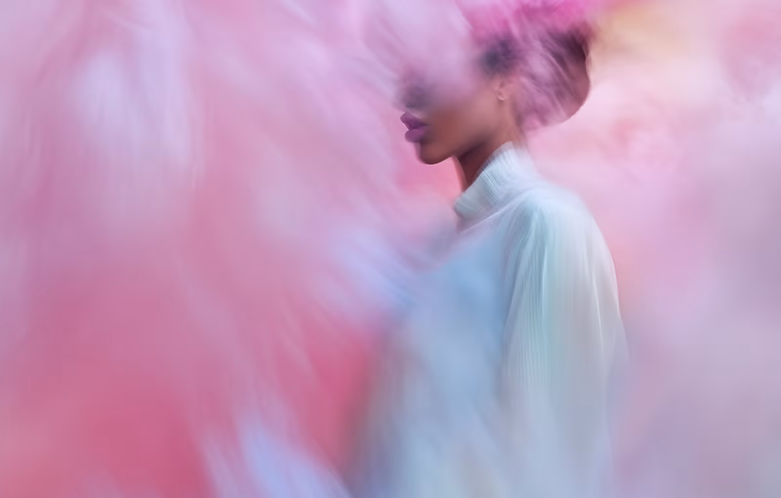 Profile of a woman in a white turtleneck surrounded by swirling pink and blue smoke or mist.