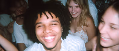 Group of young people smiling and enjoying at a social gathering.