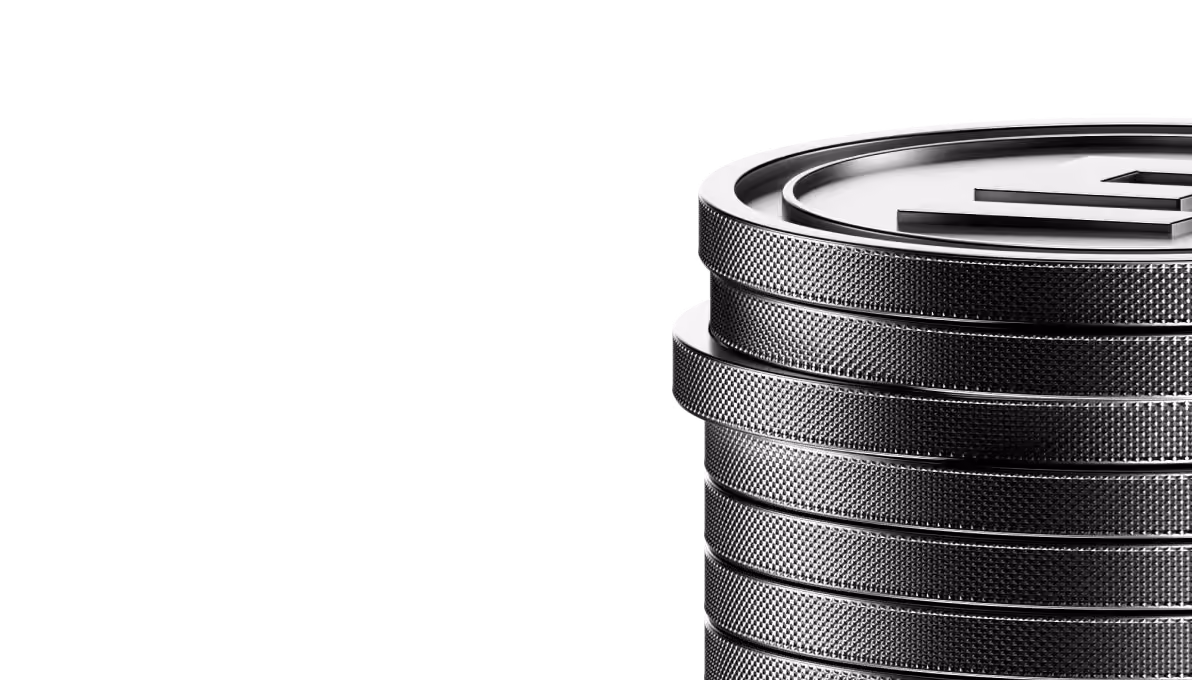 Close-up of stacked silver coins with textured edges and a raised symbol on top coin.