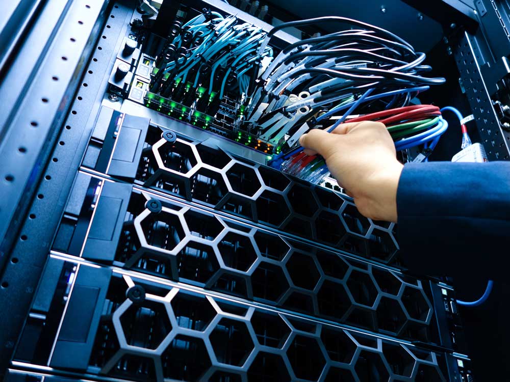 Sequel-Data-Systems-engineer-connecting-network-switch-cabling-in-a-server-rack