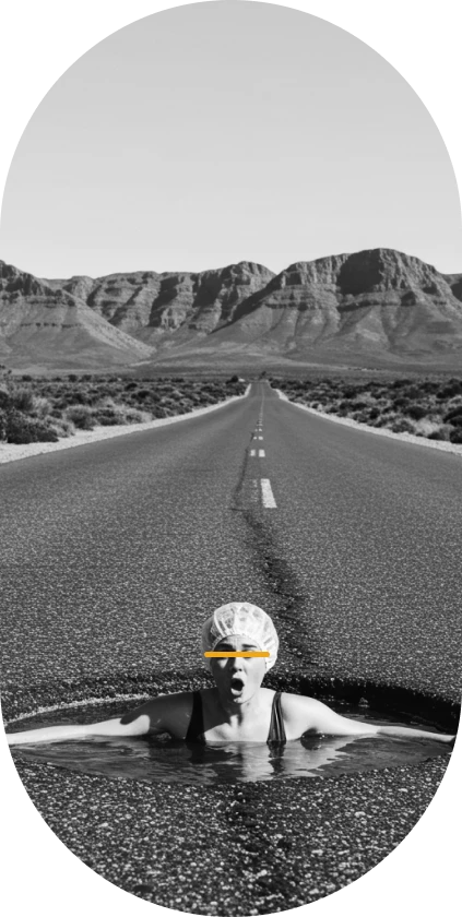 In South Africa, a woman humorously poses as if swimming in a large pothole filled with water, highlighting the road condition.