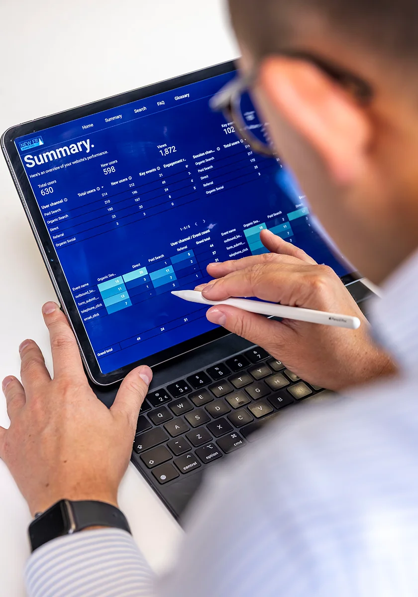 New Era Marketing performance report open on a tablet showing website traffic and channel data