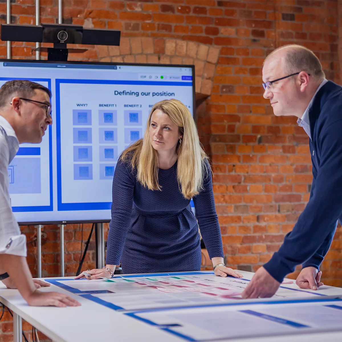 Colleagues at a workshop session discussing brand positioning on a screen