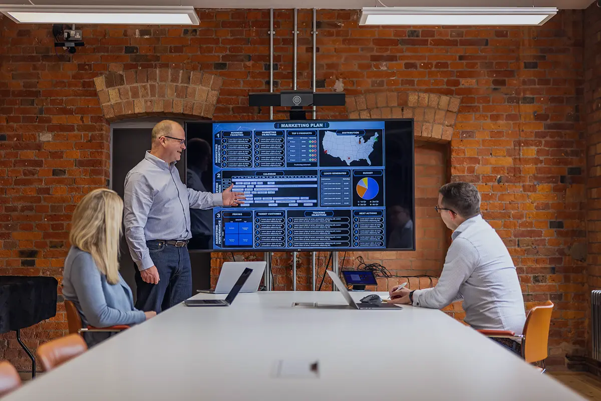 Marketing team reviewing a marketing plan on a presentation screen