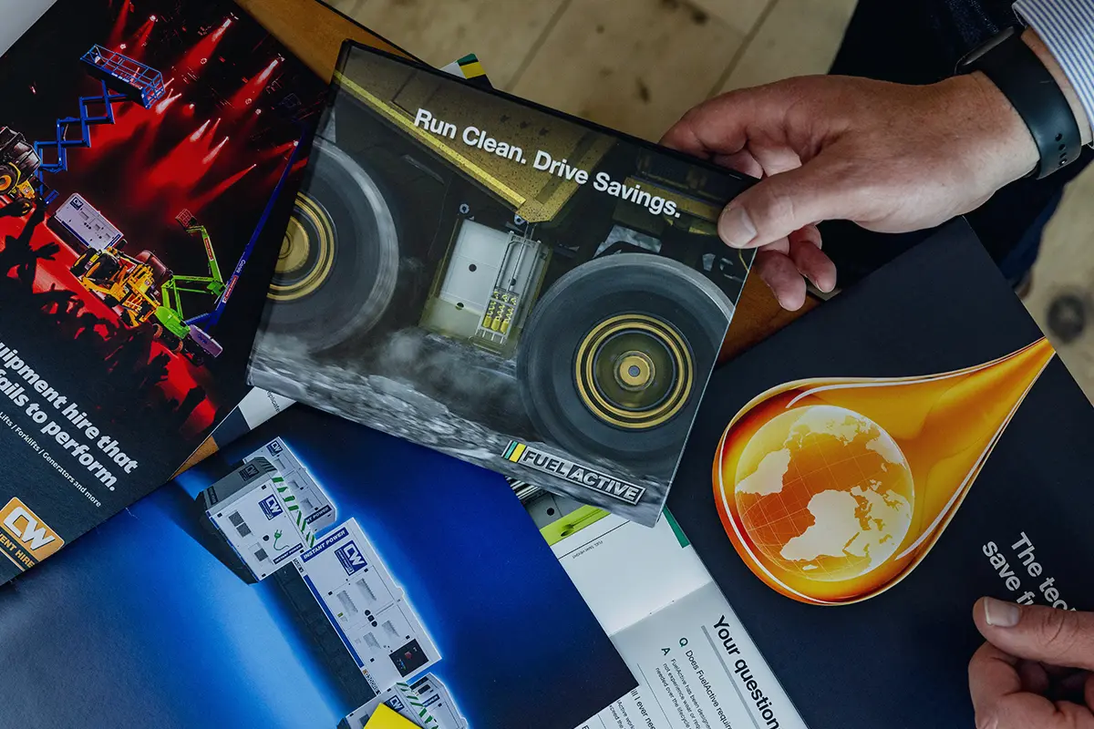 Printed brand collateral and marketing materials spread on a table