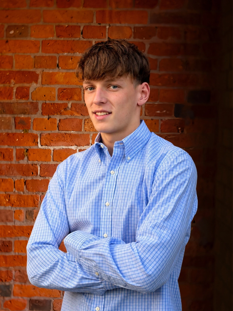 A man wearing a blue shirt and blue plaid tie.