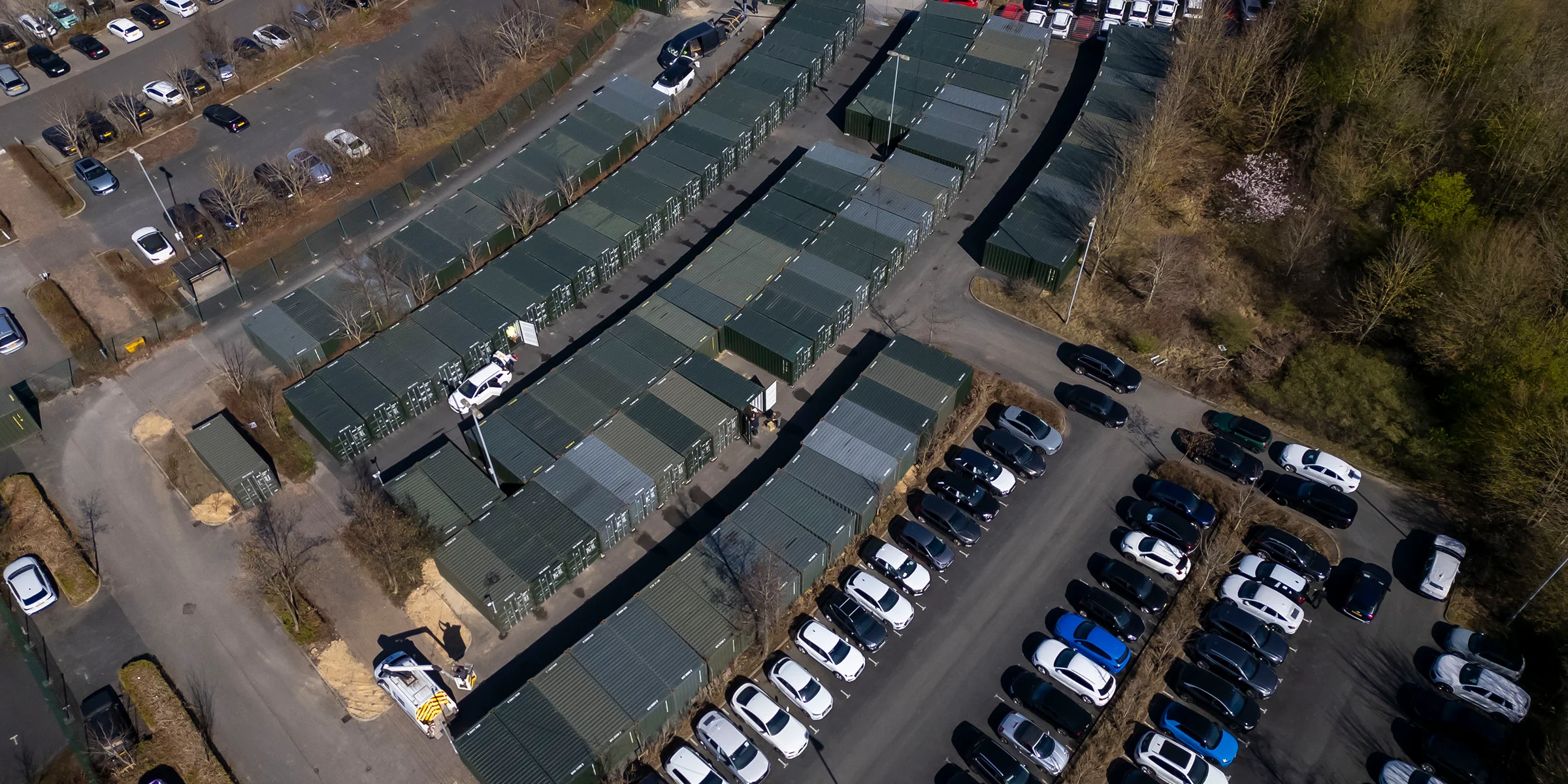 Aerial view of a Yard Self Storage site with rows of storage containers and parked cars