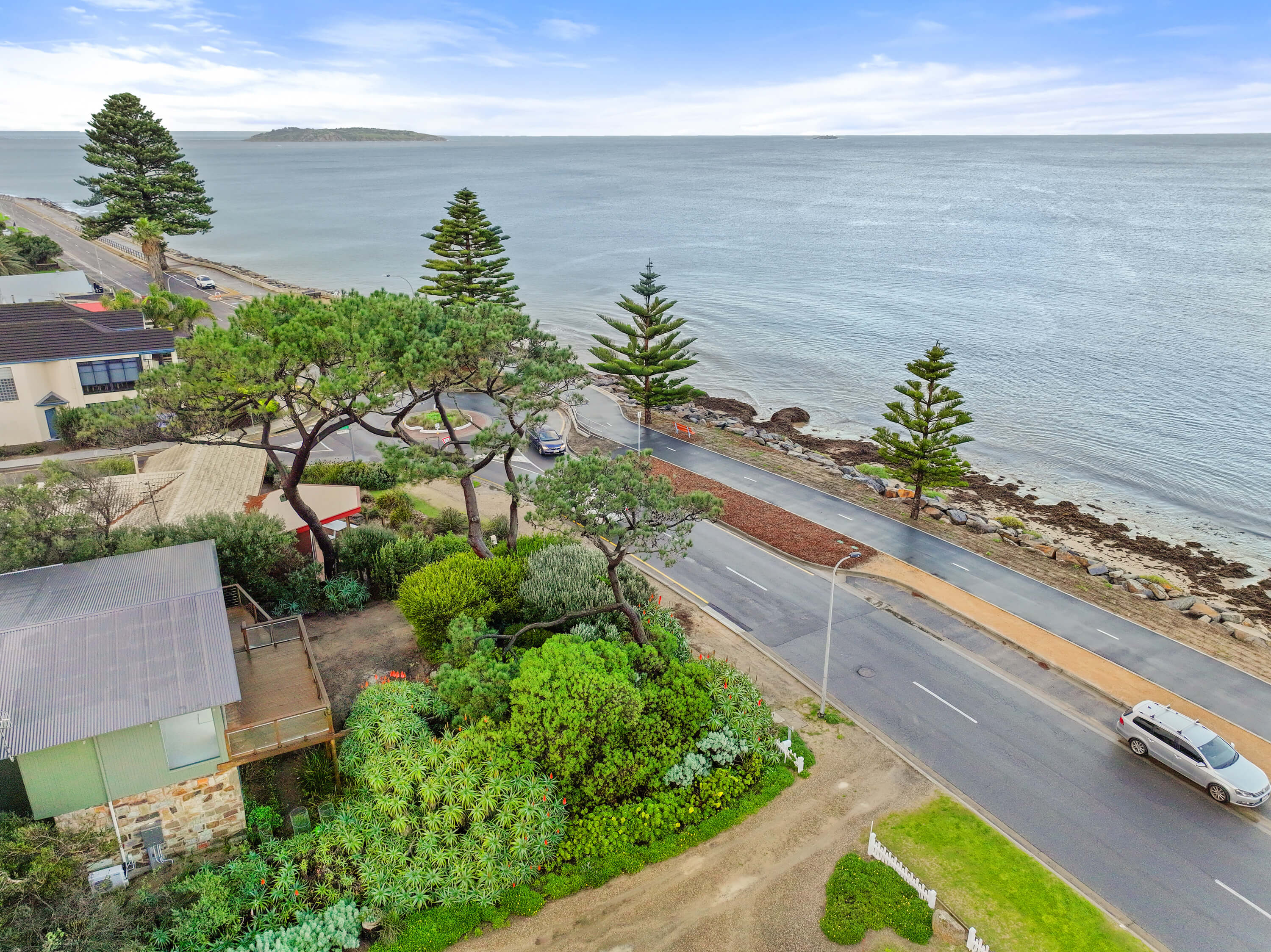 Aerial along the Encounter Bay esplanade with Norfolk pines outside Franklin Ave